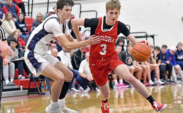 Aurora’s Brooks Handrup looks for a lane in the second half of the Huskies’ 44-36 win over Adams Central Saturday, claiming a second straight Central Conference tournament championship.