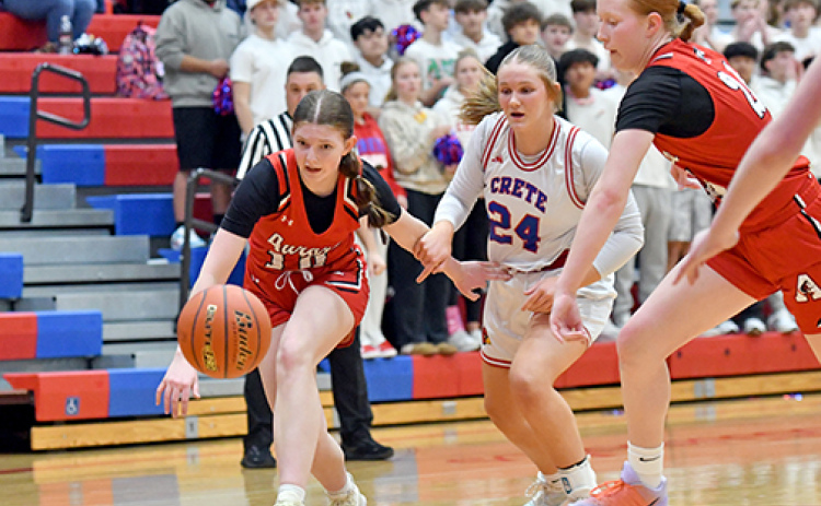 Aurora’s Kenna Merrihew (10) and Evelyn Kraus chase a loose basketball defensively during the Huskies’ season-ending loss to Crete Feb. 25.