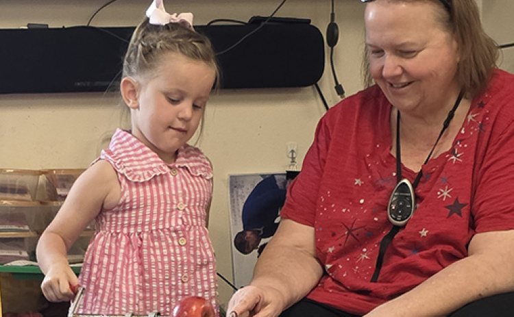 Kathryn Dyer will end a 33-year career in education, spent almost entirely in Aurora, when she retires at the end of the school year. She is shown here working with a student in the preschool building where she spent most of her career.