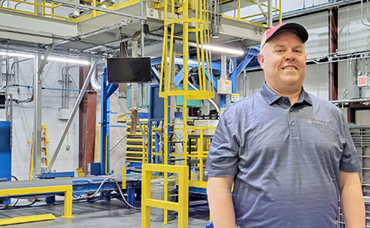 Beck’s plant manager Ryan Petr stands in front of a seed corn bagging/boxing machine in the huge processing facility near Phillips. Though empty now, the plant will begin to fill up with locally harvested seed corn starting in September.