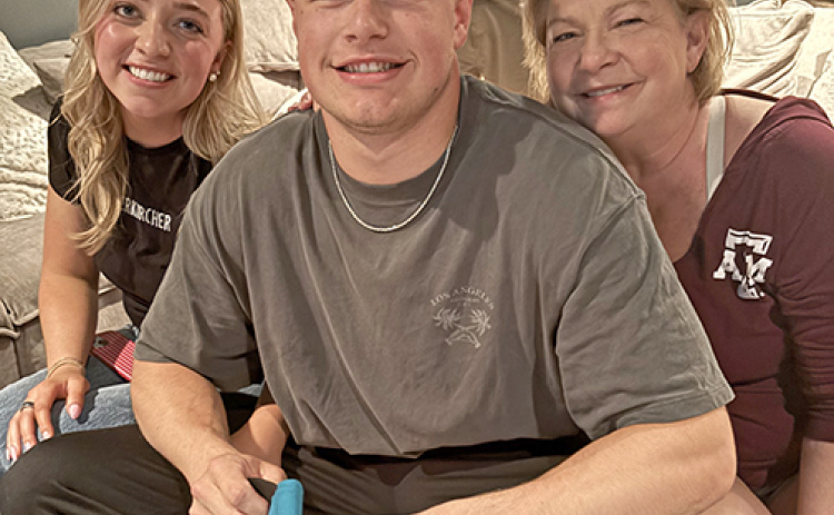 Aurora native Nate Boerkircher holds a Jacksonville Jaguar hat in his hands, shortly after hearing his name called in the second round of the NFL draft. Pictured with him are his fiance, Paxtyn Dummer, and mother Sherry.