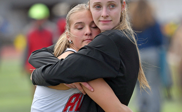 Stella Peterson (left) and Kaitlyn Staehr hug it out after finishing fifth and second respectively in Thursday’s triple jump event.