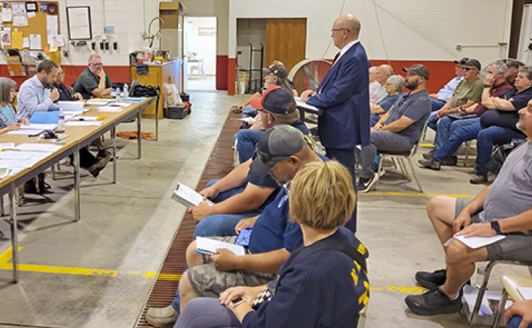 Gothenburg attorney Mike Bacon (standing) addresses the Phillips Village Board meeting as the Community Development Agency, to present a request for TIF financing for six new rental units proposed to be built by Bartunek 3D Enterprises.