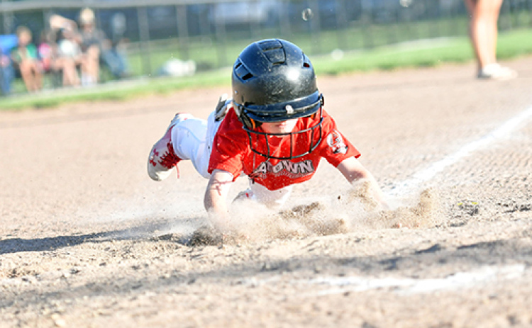 Walker Griffith goes all-out with an aggressive head-first slide into home plate.