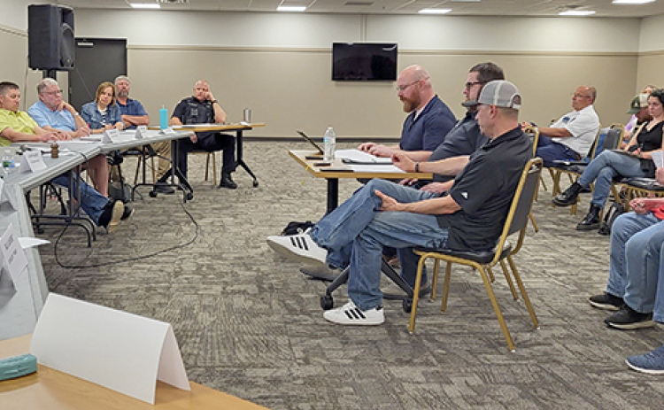 Members of a citizens focus group (seated at center table) present their findings during a report to the Aurora City Council at a May 26 meeting which drew approximately 40 people to the Bremer Center.