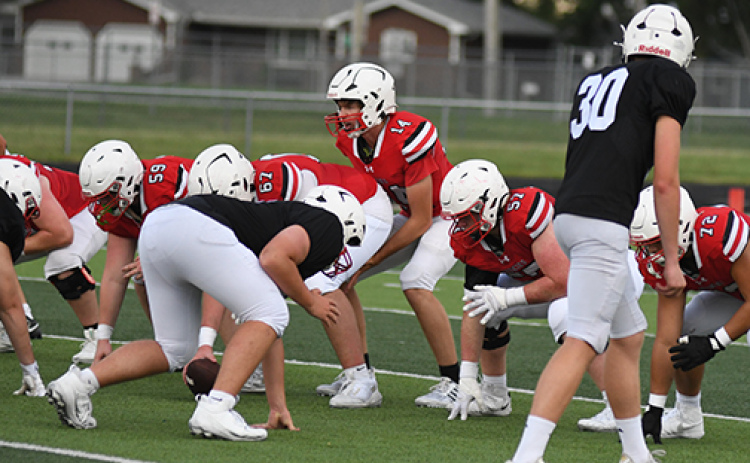 Sam Jones (14), who is expected to share time under center with senior Wyatt Pollet, takes a snap with the No. 1 offense during Friday’s final preseason scrimmage.