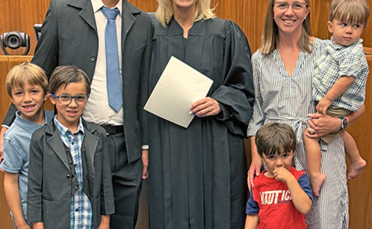 The Edwin Gomez family poses for a picture with Federal Judge Susan Bazis following the July 17 ceremony in Lincoln in which Edwin and a group of others were sworn in as U.S. citizens. Included in the picture are Gomez’s wife, Allie (Mitchell) and their four sons, from left: Benji, Zeke, Eliseo and Zeb.