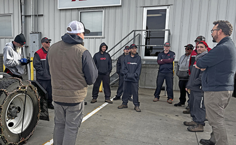 Safety training is on-going at the XPO service center in Aurora. Pictured here during a training exercise last November, driver trainer Lee Schuppan talks to drivers about when and how to apply snow chains.