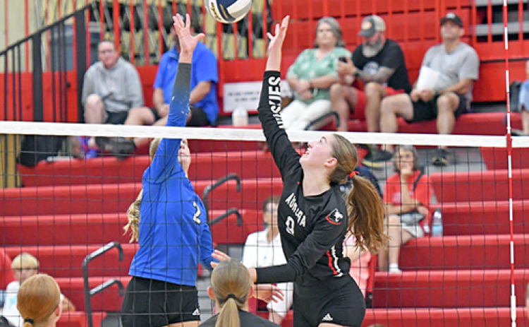 Aurora’s Elizabeth Luebbe and Malcolm’s Payton Dolliver go for the same ball at the top of the net in what was a three-set winner for the Huskies.