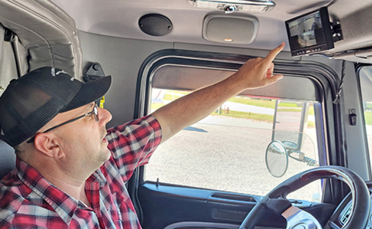 Acord Transportation Regional Manager Mike Bronzynski points to the monitor in the cab of his truck that shows the views of the four different mounted cameras offering various views of the road and the trailer both behind and ahead.