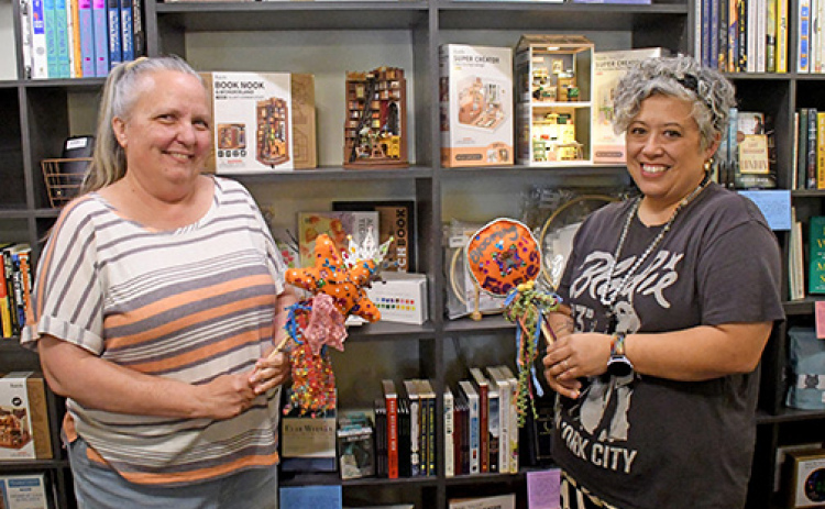 Espressions co-owners Lisa Montoya (left) and Maile Ilac Boeder show off some of the new books and other items that have been added to the newly renovated shop.