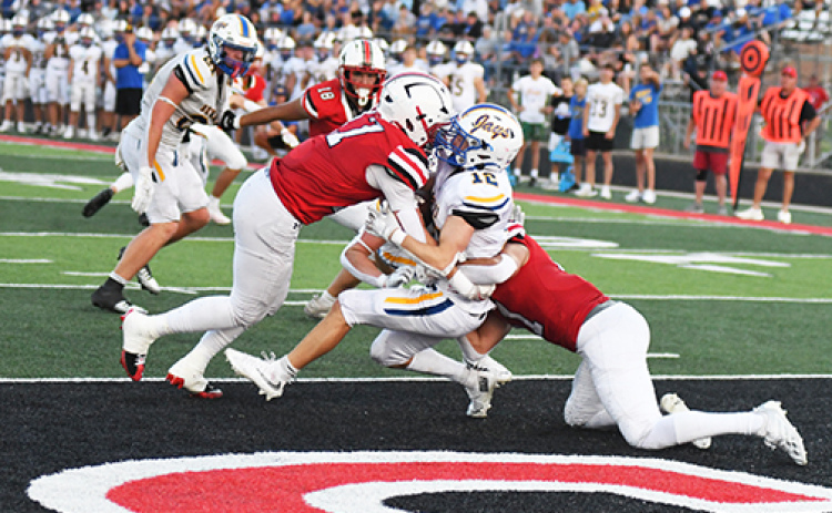 Aurora seniors Hudson Decker, left, and Malakai Camacho smother Seward running back Carter Hanes in the end zone for a second-quarter safety. The Huskies led 22-3 at the half and pulled away for a convincing 43-10 win in a return to Class B football.