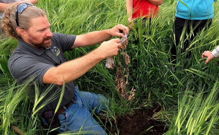 Jay Goertzen holds up what is barely left of one of the pairs of underwear, three months after it buried at the Grain Place Farm.