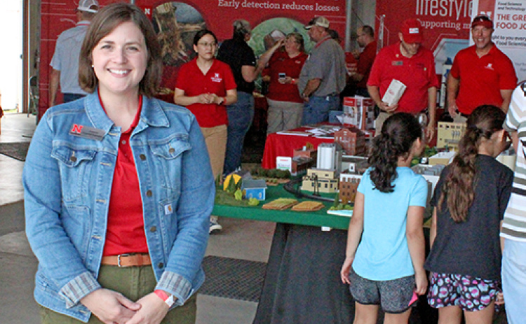 Extension Educator Jordan Grummert Rassmussen stands inside the Big Red Building at the recent Husker Harvest Days where various Extension booths were located. Rassmussen is the program area leader for Rural Prosperity Nebraska, an Extension program that helps rural communities develop new leaders and plan for the future.