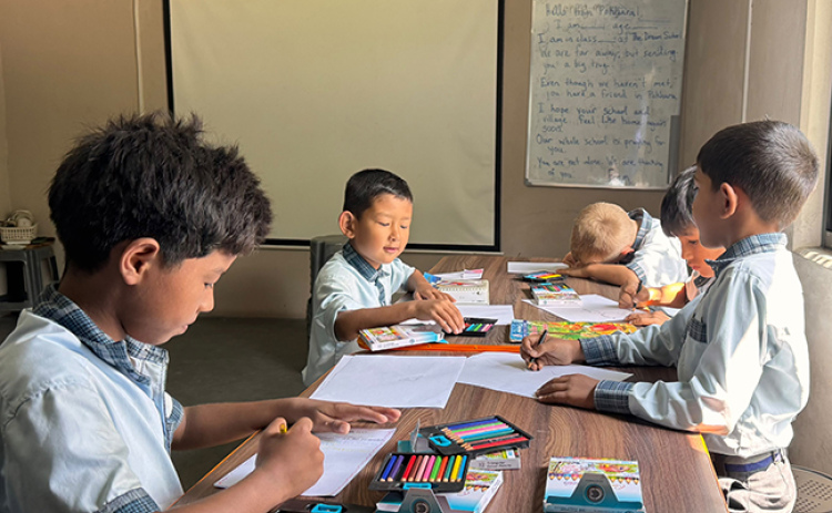 The Dream School is working with their students and families to help assemble 300 backpacks containing school supplies for children who lost their belongings. Students at The Dream School are pictured here creating cards to include in the backpacks.
