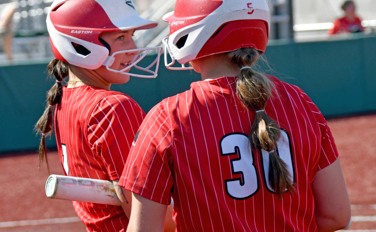 Londyn Teahon (1) and Makaylah McCartney chat before their at-bats during Aurora's loss to York in Thursday's district contest.