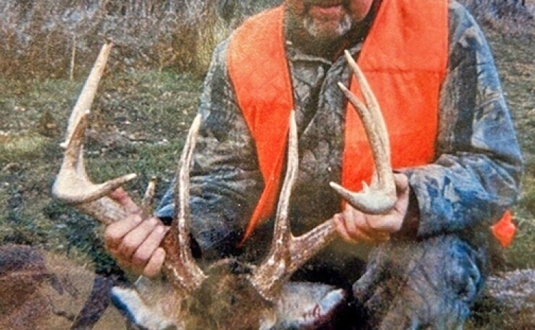 Deryl Hilligas poses with buck he took down on the last day of black powder season in 2004. The deer has unusually long brow tines measuring 11 inches.