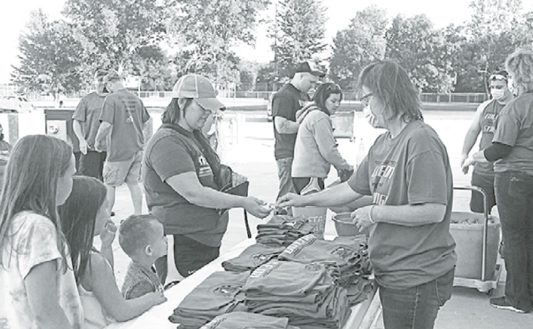 Penny Evans (right) sells “Coleton Strong” shirts at the Phillips Memorial Hall to help raise funds for the family’s medical costs. News-Register/Jeni Moellenberndt