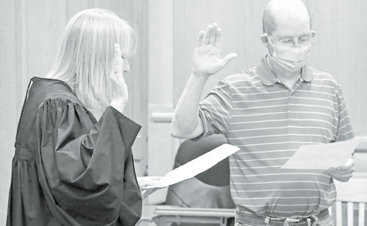 Judge Rachel Daugherty (left), raises her right hand and recites the oath of office with newly appointed District 3 Commissioner John Thomas. News-Register/Cheyenne Rowe