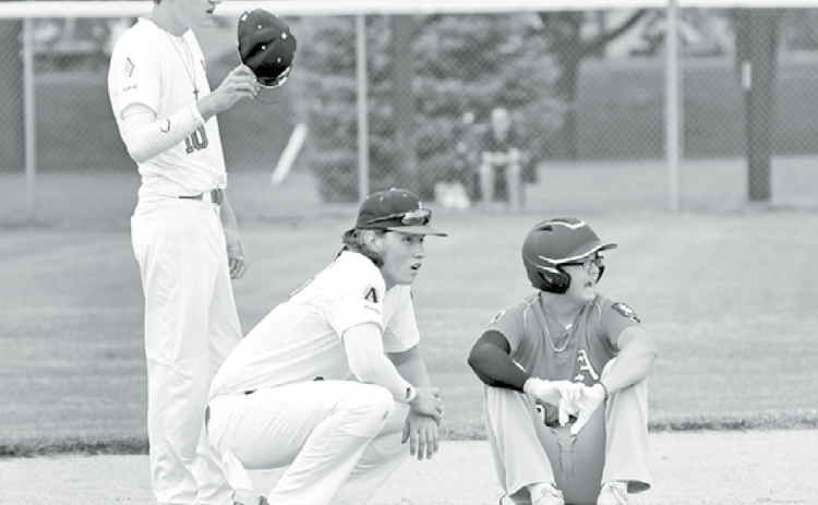 From left, PB White’s Cayden Phillips, Cam Jones and AC Red’s Kyle Larson catch their breath as a new pitcher warms up mid-game. News-Register/Richard Rhoden