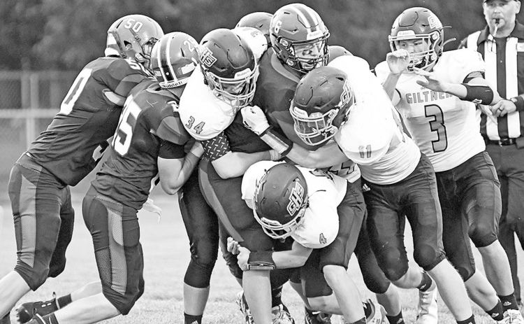 A swarm of Hornet defenders aim to bring down Heartland’s Nolan Boehr during Giltner’s 72-26 loss to the Huskies in the season-opener Friday night. News-Register/Richard Rhoden